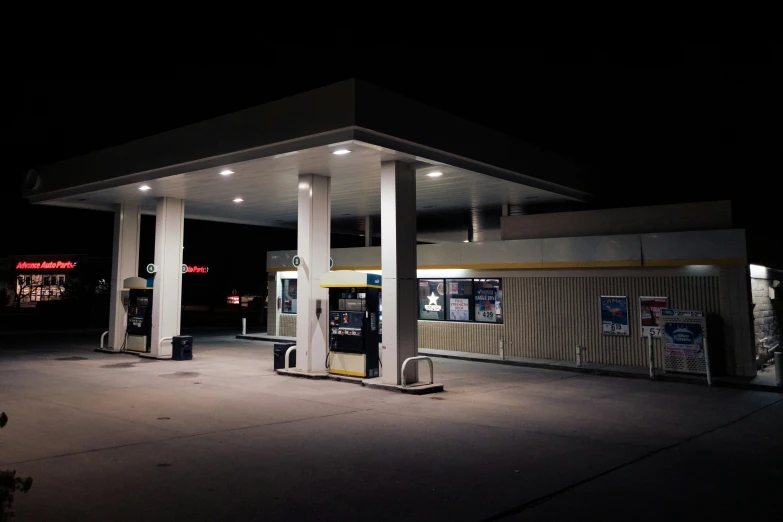an empty gas station at night lit up by lights