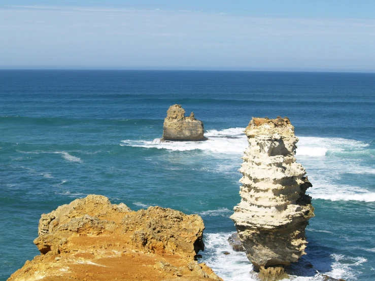 a cliff with three massive rock formations on it