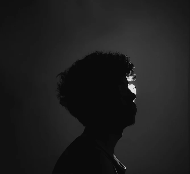 a person standing up against a dark background