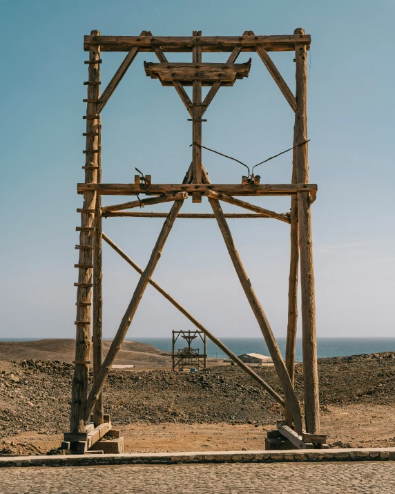 a very tall wooden structure sitting on top of a beach