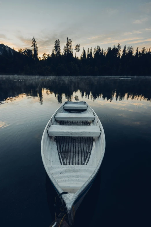 a boat sits on the water as the sun goes down