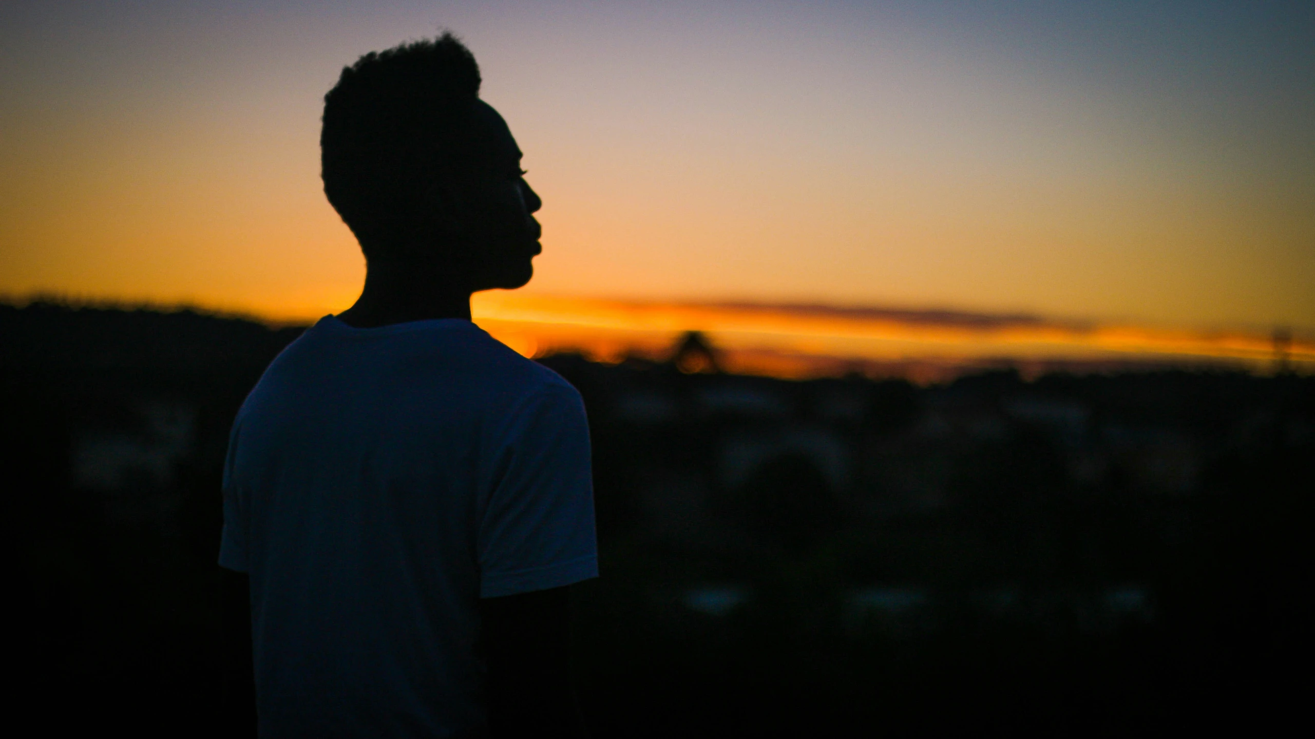 a man with a bird on his shoulder at sunset