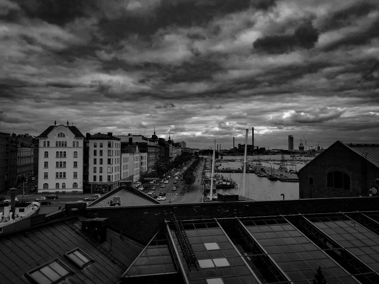 dark clouds hover over a cityscape and bridge