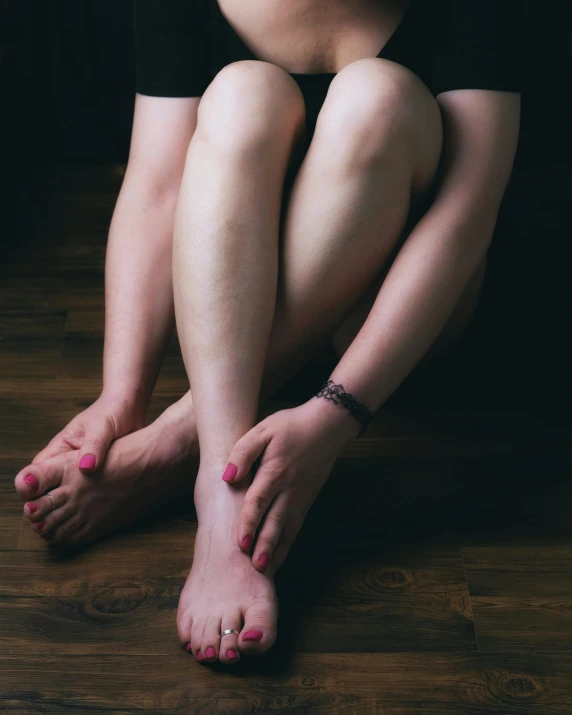 a girl sitting on the floor with her bare feet