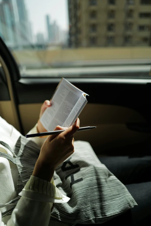 a person that is writing in the back of a car