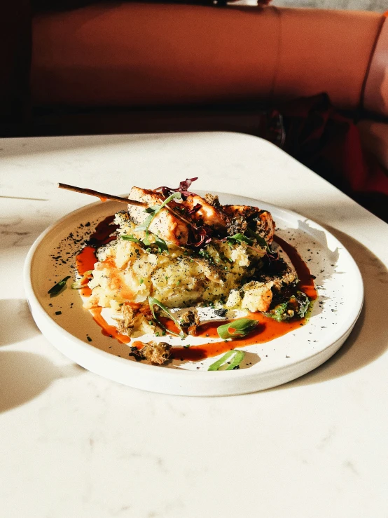 a plate of seafood and grits on a white table