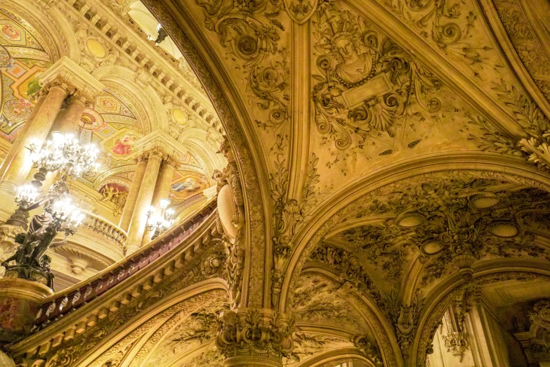 the ceiling in an ornate cathedral has gold paint