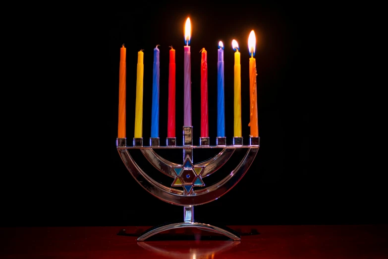 an arrangement of brightly lit candles in front of a black background