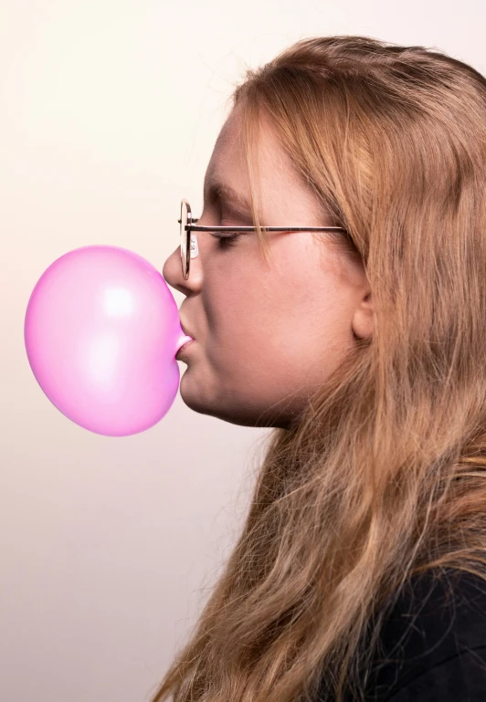 a person blowing out a balloon in the air
