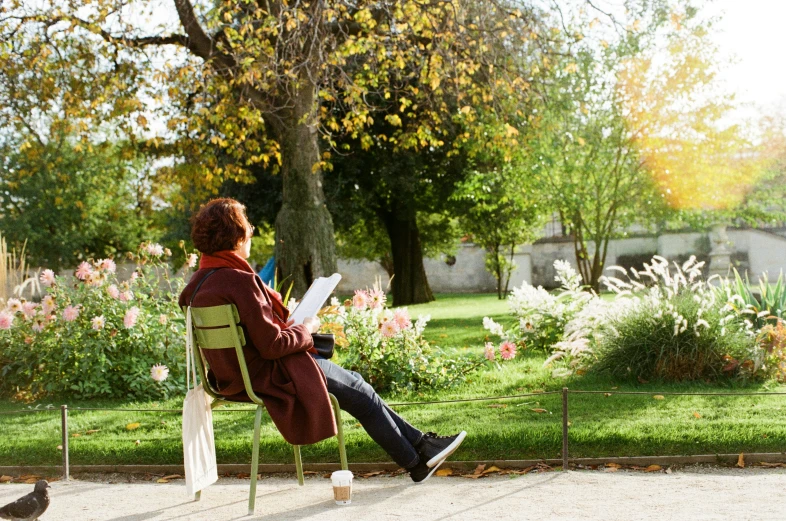 the woman is reading on her lawn chair outside