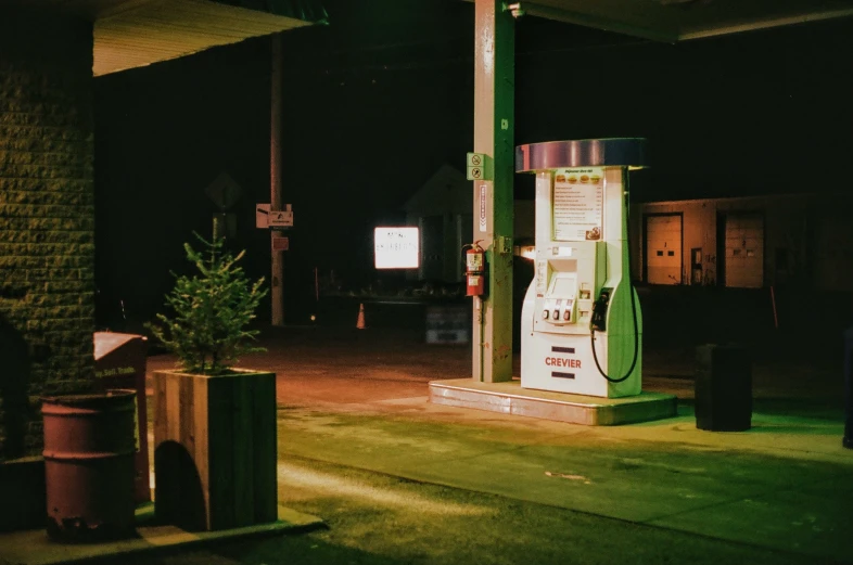 an old gas pump in the dark, with its light on