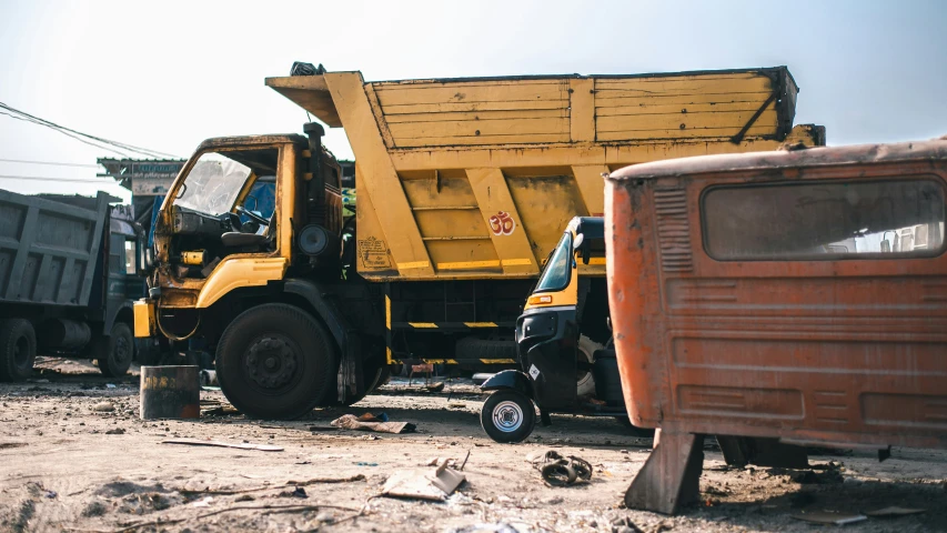 a construction truck and other dump trucks on dirt