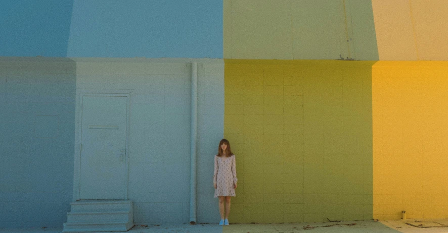 a young woman stands in front of four brightly colored squares