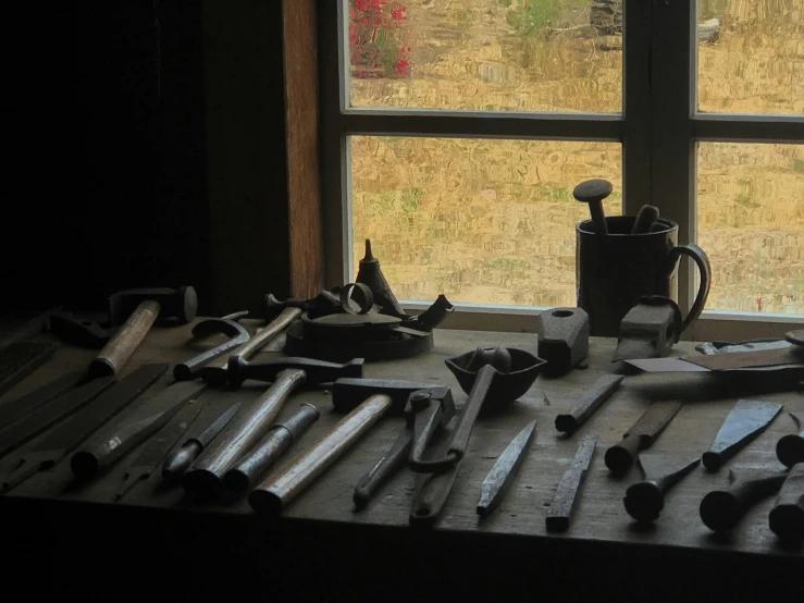 a wooden table with various items on it next to a window