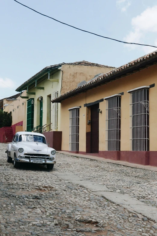 an old - fashioned car is parked in front of two buildings