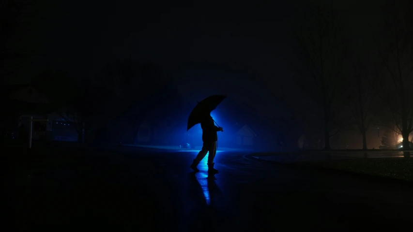 person holding an umbrella in the dark of the night