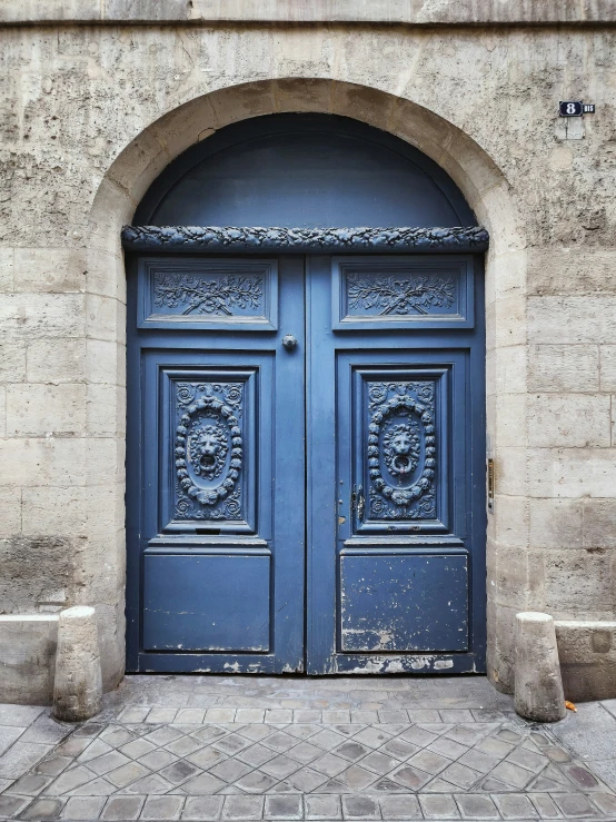 an ornate door to a building has two arched doors