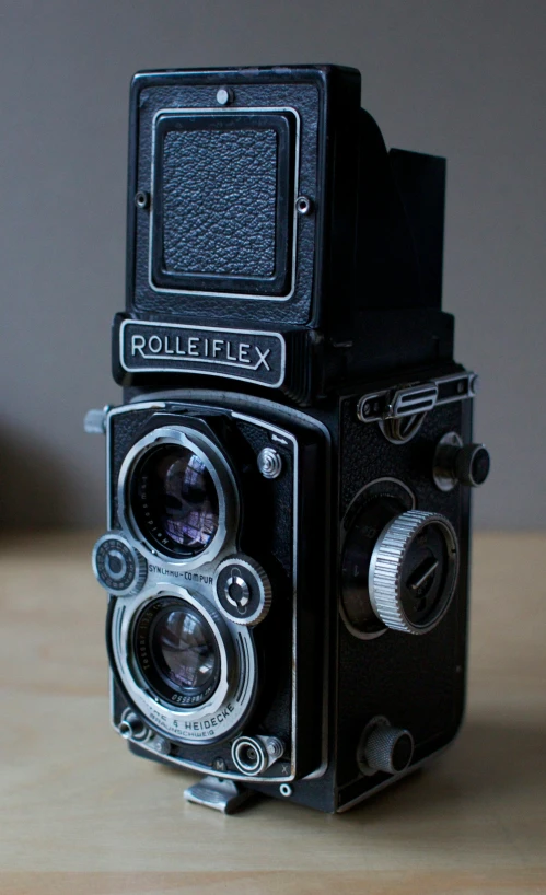 an old camera is sitting on a wooden table