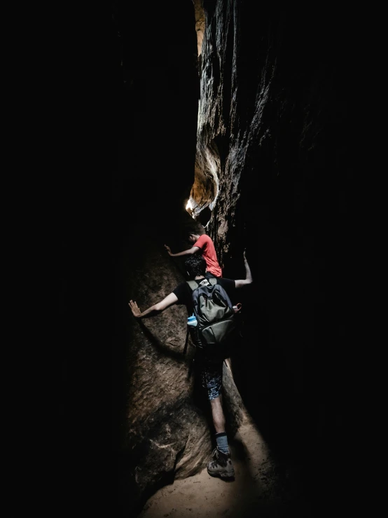 the young man is climbing up the side of the tree