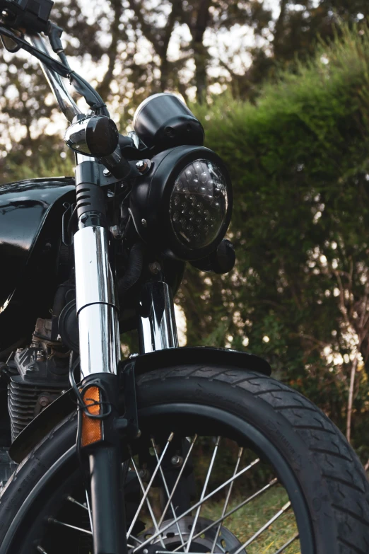 a black motorcycle parked next to some trees