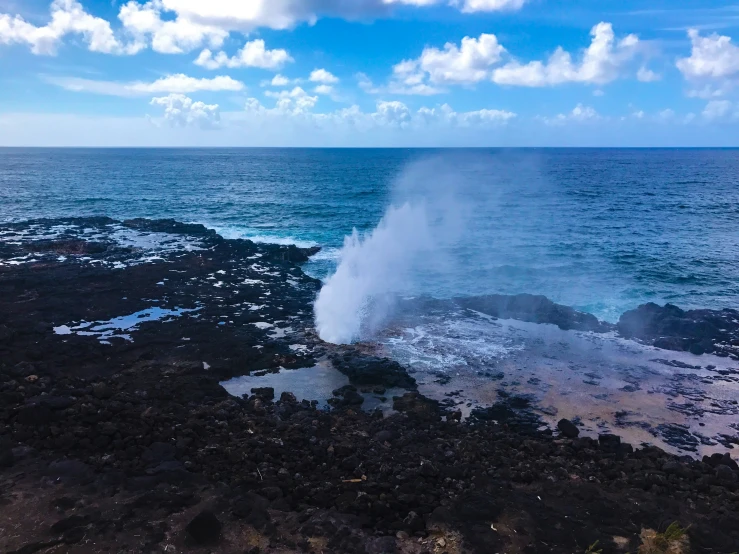 the geyser falls out into the ocean as clouds roll in