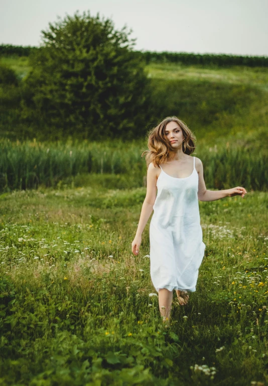 a woman is walking through a field