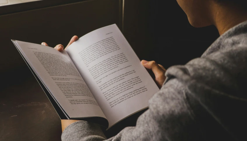 a woman reading a book in the dark