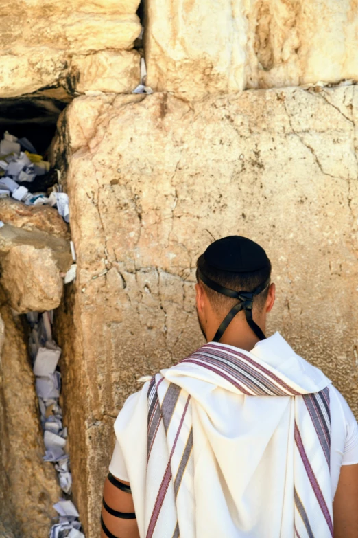 a man with an over sized scarf and hair in a religious area