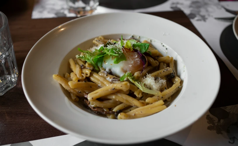 pasta with herbs in an ornate white dish