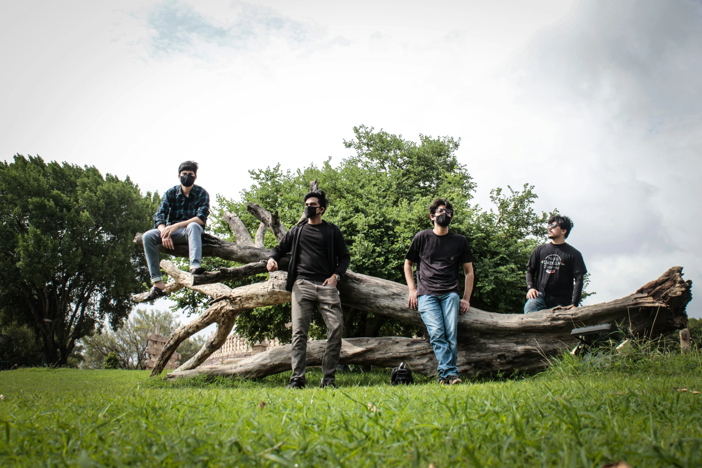 four guys that are sitting on some logs