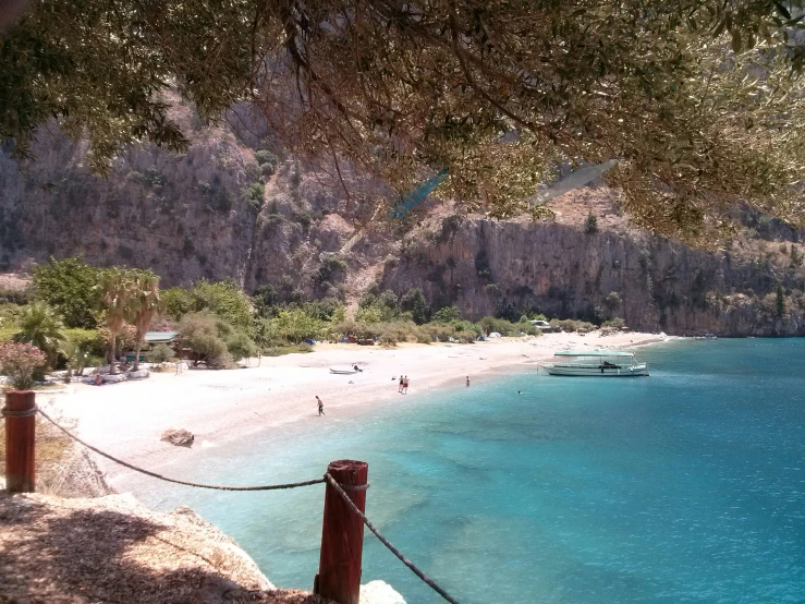 a body of water with white sand and trees on the shore