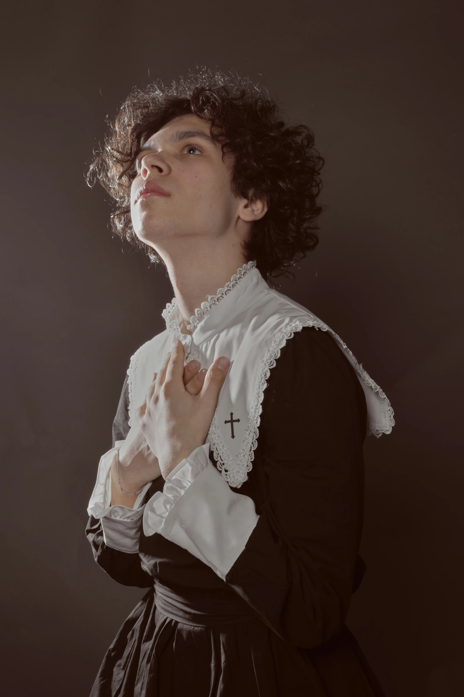 a young person wearing an historical costume with hand on chest