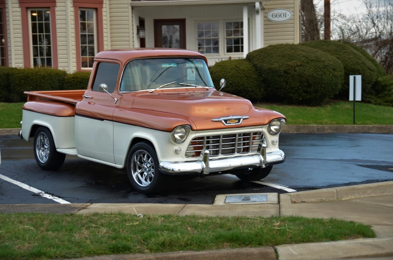 old fashioned pickup truck with open flatbed in lot