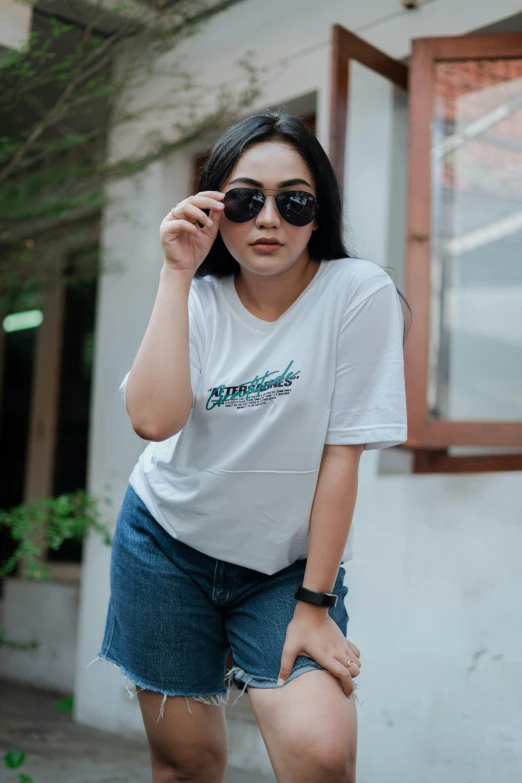 a woman wearing sunglasses poses on the street