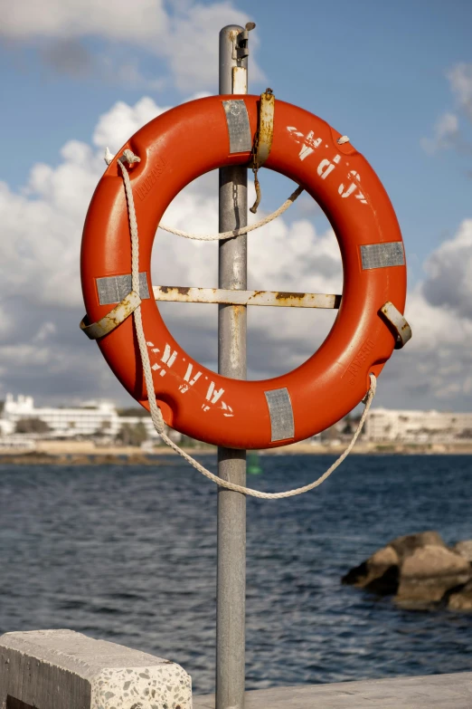 the life preserver hangs up on a post along the water