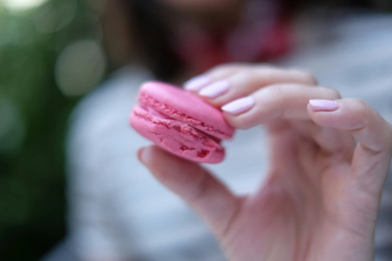 woman holding pink doughnut shaped like heart shaped cookies