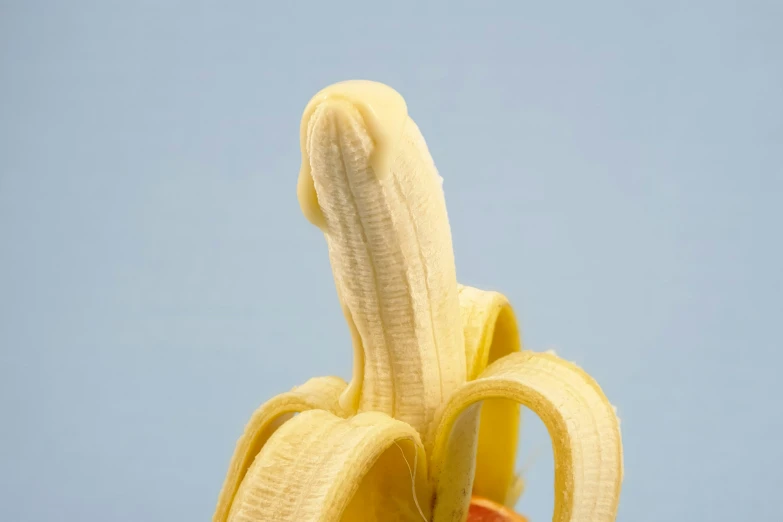 a banana peel sticking out of a single half peeled bananas