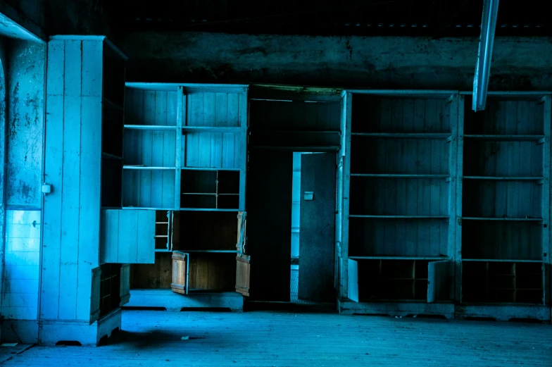 empty wooden shelves are lit by the blue light from behind