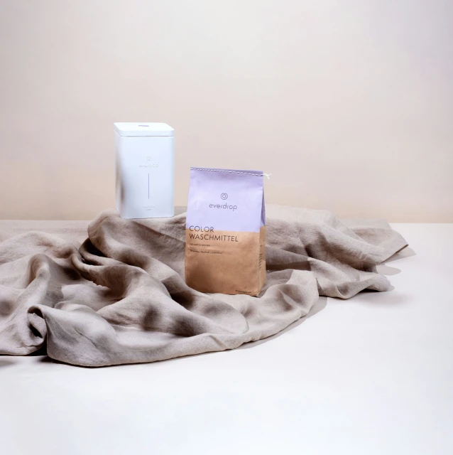 a towel, cup and vase sitting on the ground