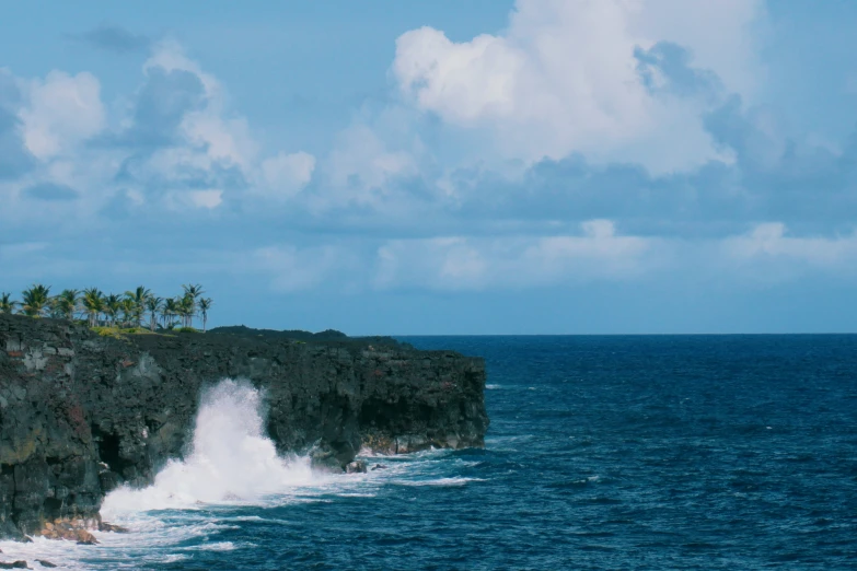 an island with waves crashing over the cliffs