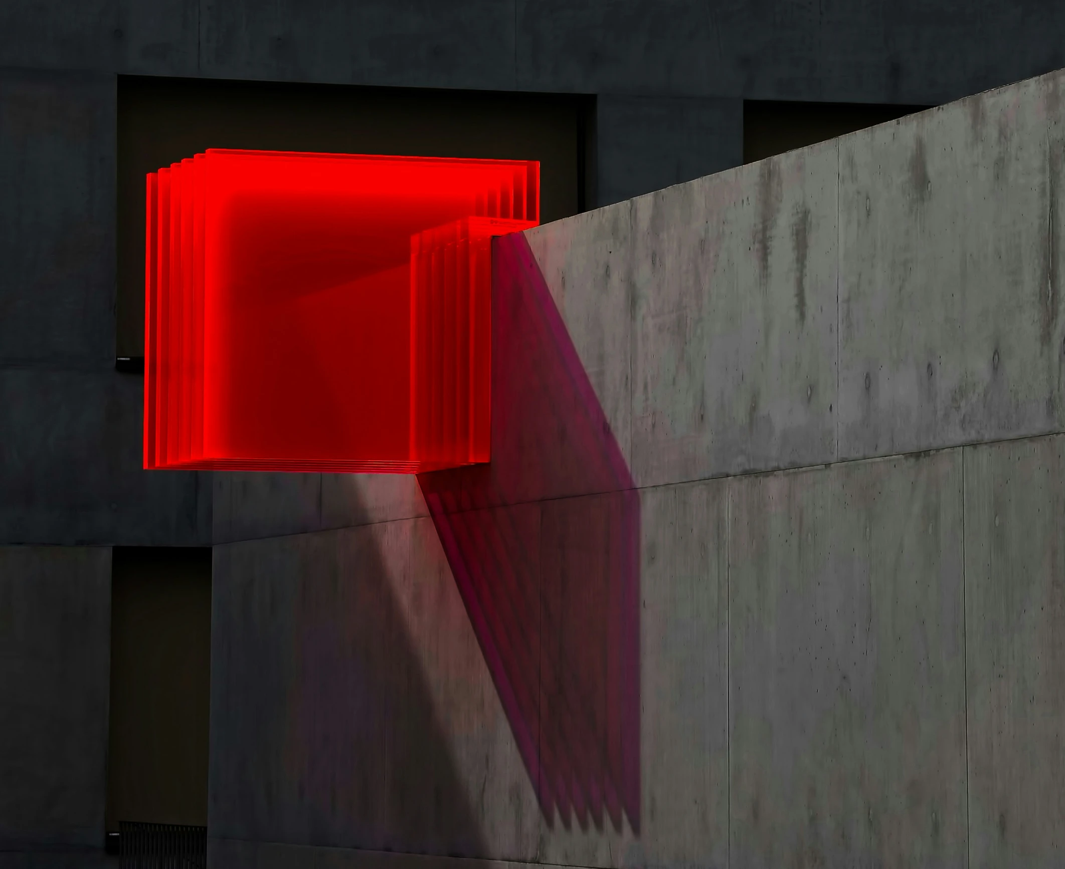 the red light is coming out of the concrete wall