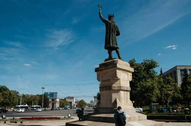 people are gathered at the base of a statue