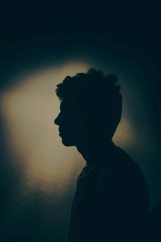 a person in silhouette in front of a wall