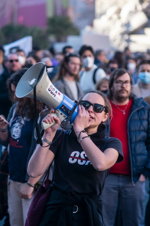 the woman in the crowd is talking on her megaphone