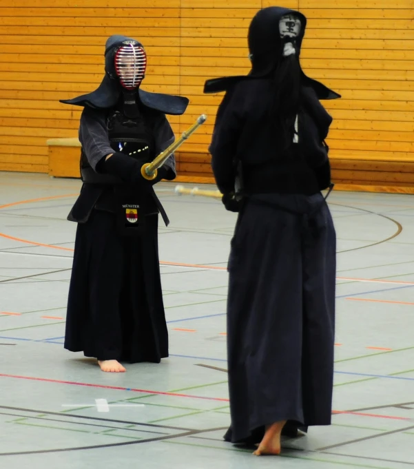 two people dressed in ninja costumes standing on a court