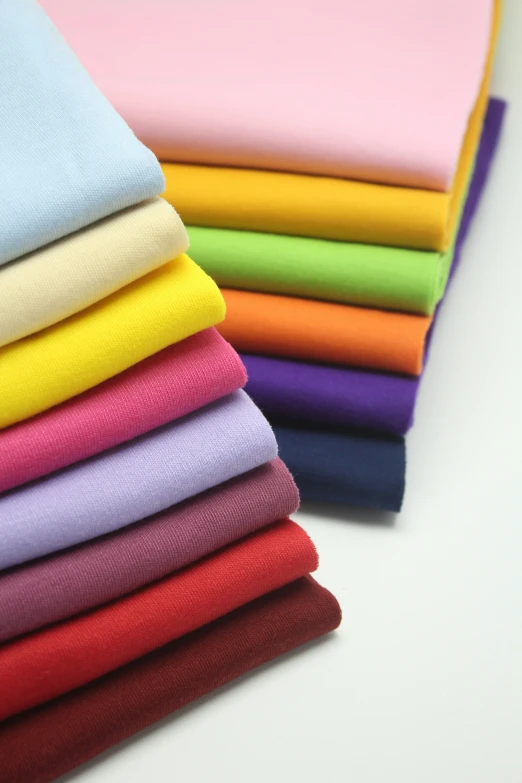 an assortment of colored fabric in a stack