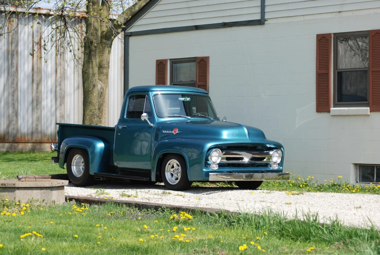 the vintage truck is parked next to a house