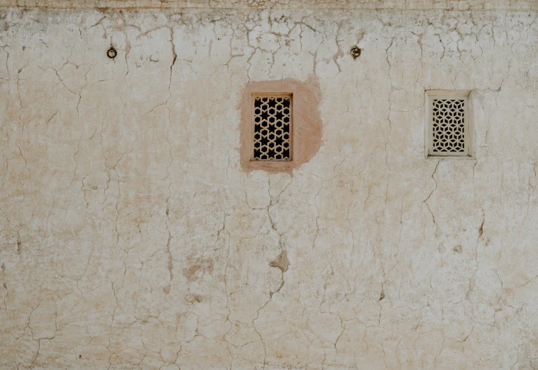 two square and two rectangle windows on a tan concrete wall