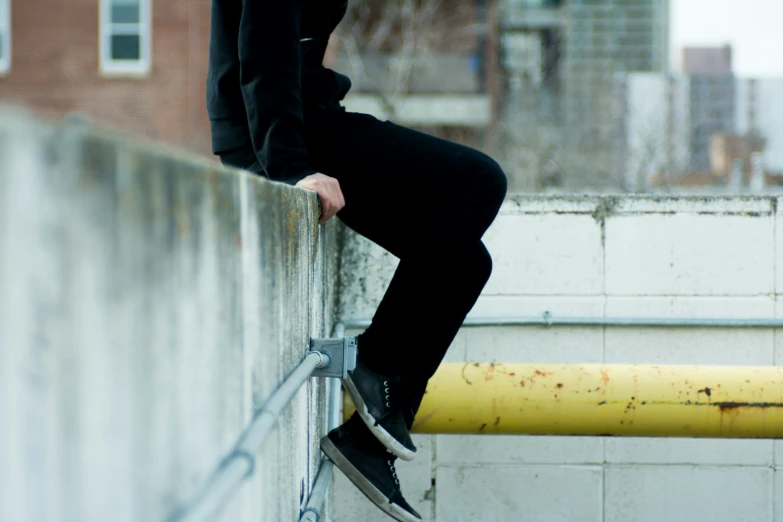 a man leans over a metal railing on top of a building