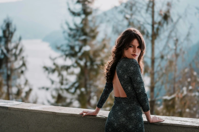 a woman with her back turned standing by a railing